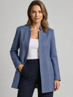 Blazer entallado azul sin cuello, cierre frontal y solapa minimalista
