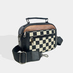 Bolso bandolera compacto negro con frontal de cuadros y cierre con tirador metálico