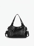 Bolso bandolera de piel sintética negro con asa doble y correas laterales, varios bolsillos.