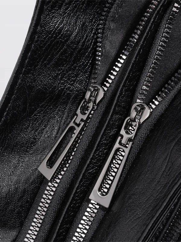 Bolso bandolera de piel sintética negro con cierre de cremallera metálica y tiradores plateados.