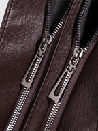 Bolso bandolera de piel sintética marrón con cremalleras metálicas dobles y tiradores plateados.