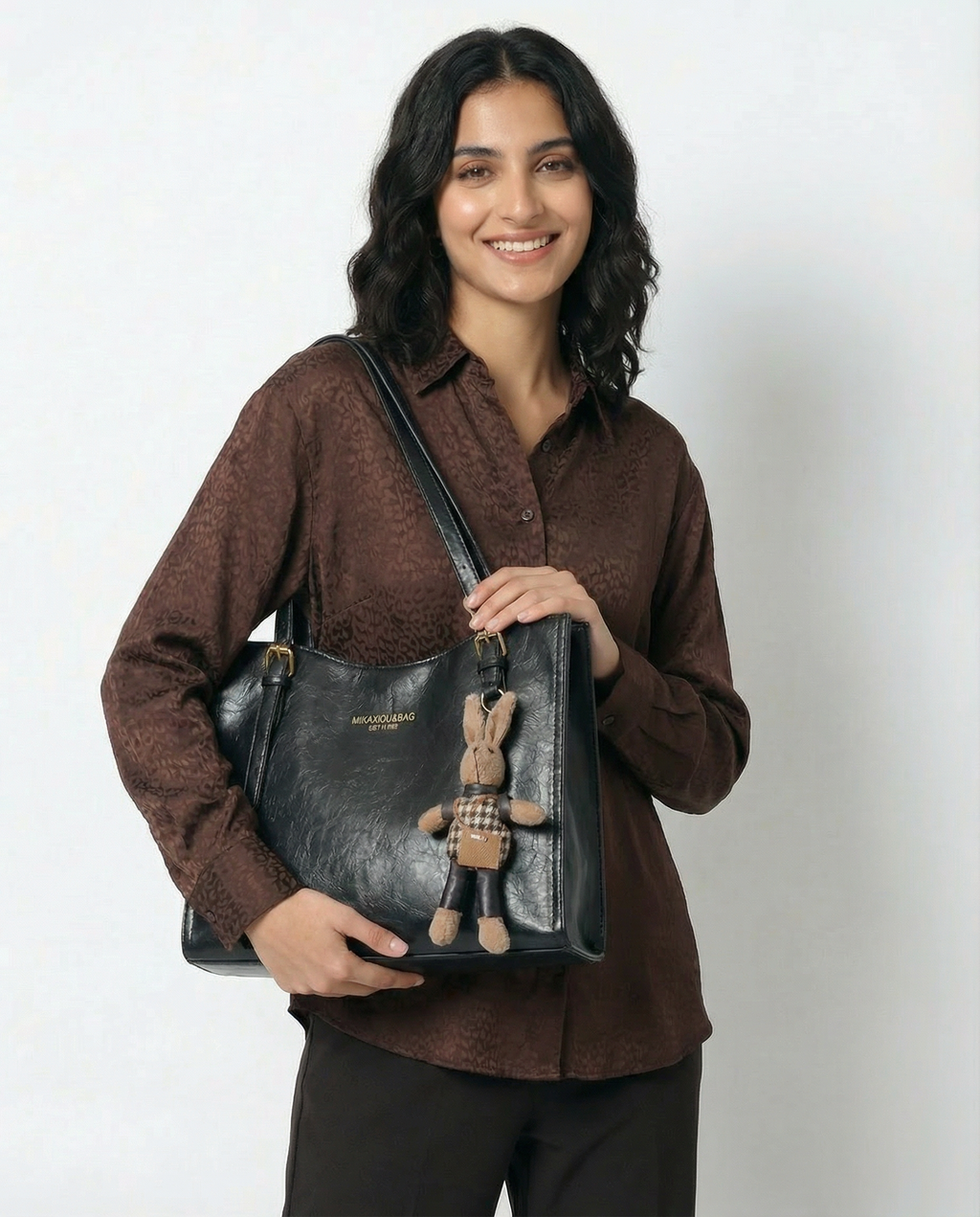 Bolso piel sintética marrón con asa doble y colgante decorativo de conejo