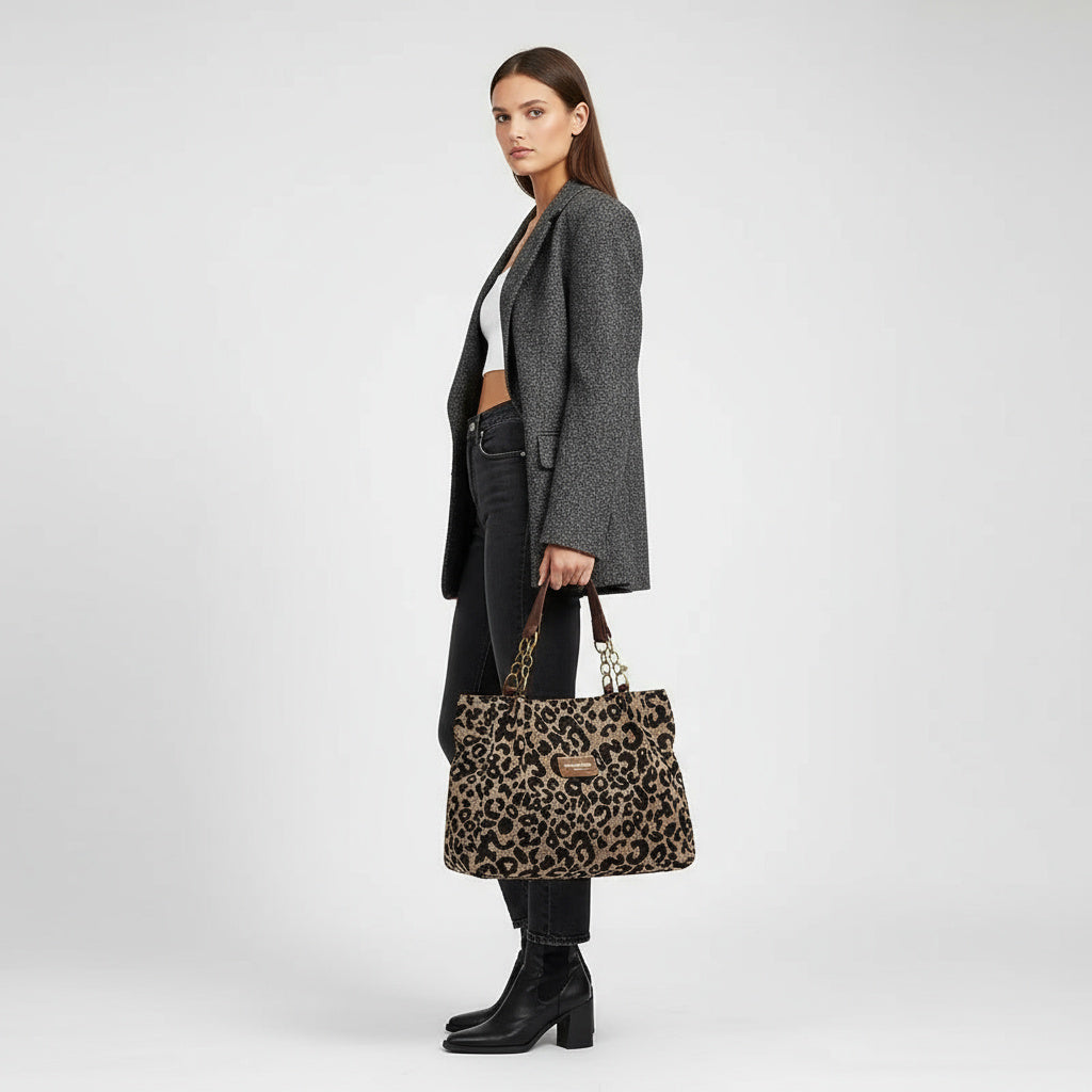 Bolso de cuero sintético con estampado leopardo visto de lado, asas marrones