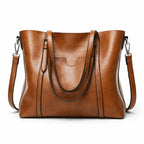 Bolso de hombro marrón con doble asa, bandolera extraíble y bolsillo frontal
