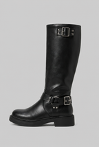 Bota biker alta negra de perfil, con correas y hebillas metálicas en la caña y el tobillo.