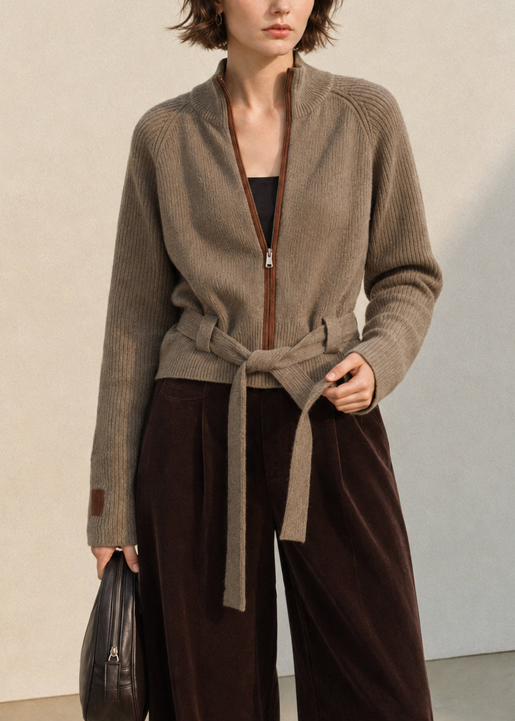 Cárdigan de punto beige con cuello alto, cremallera y lazadas delanteras a la cintura