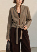 Cárdigan de punto beige con cuello alto, cremallera y lazadas delanteras a la cintura