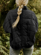 Chaqueta acolchada oversize negra con cuello alto, vista trasera y cierre