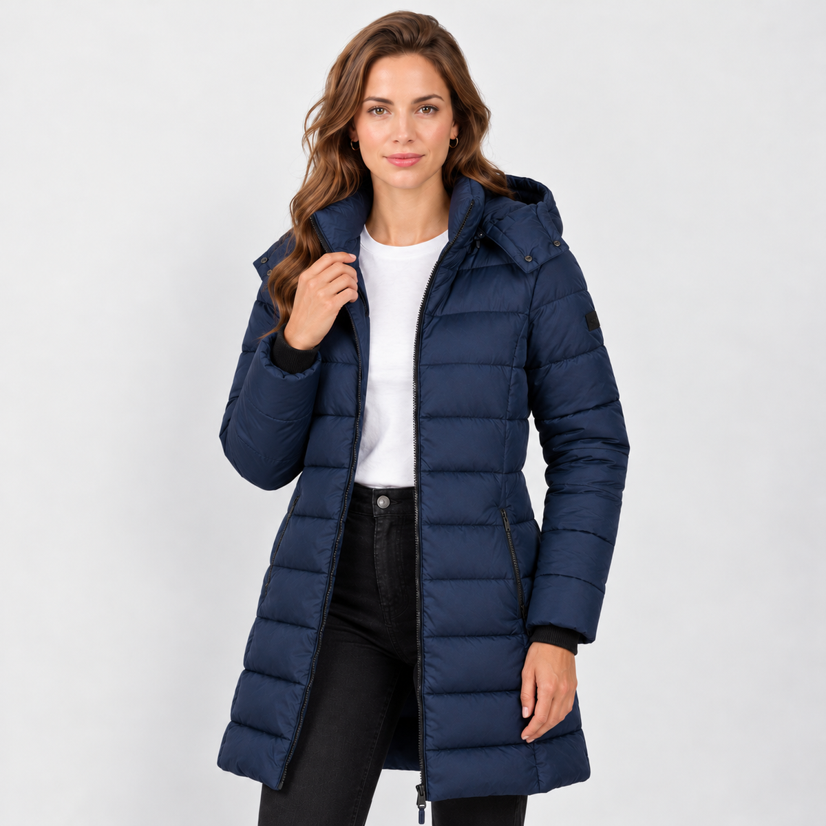Chaqueta acolchada azul marino con capucha y bajo largo, abierta por delante.