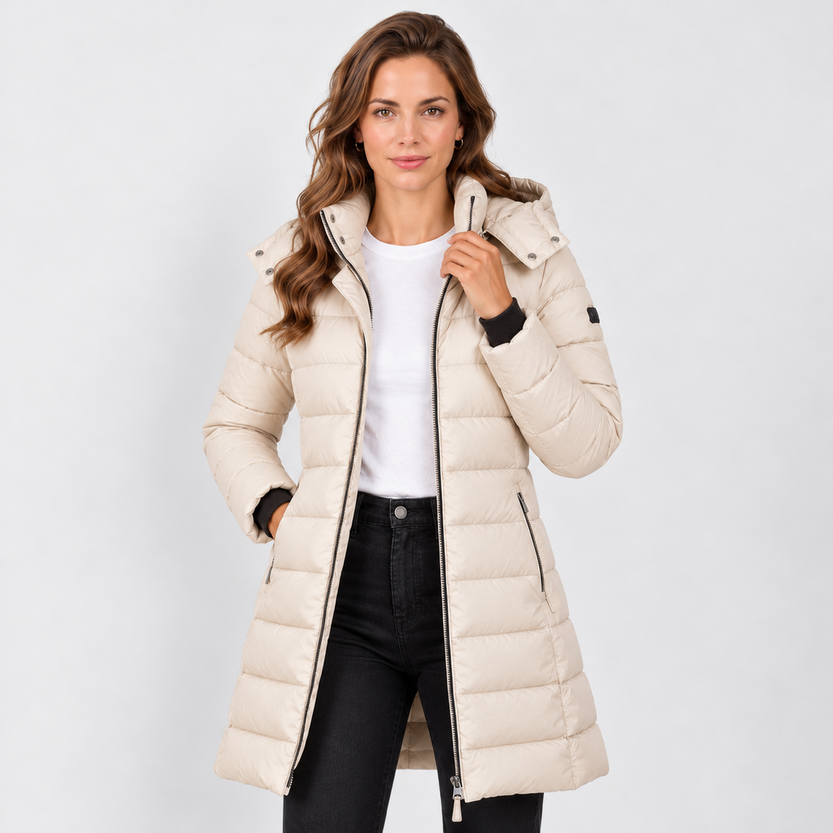 Chaqueta acolchada beige larga con capucha y cierre frontal.