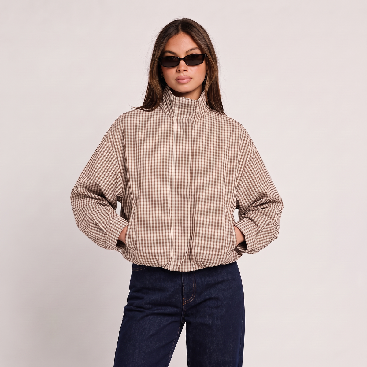 Chaqueta bomber corta de cuadros beige con cuello alto y cierre frontal