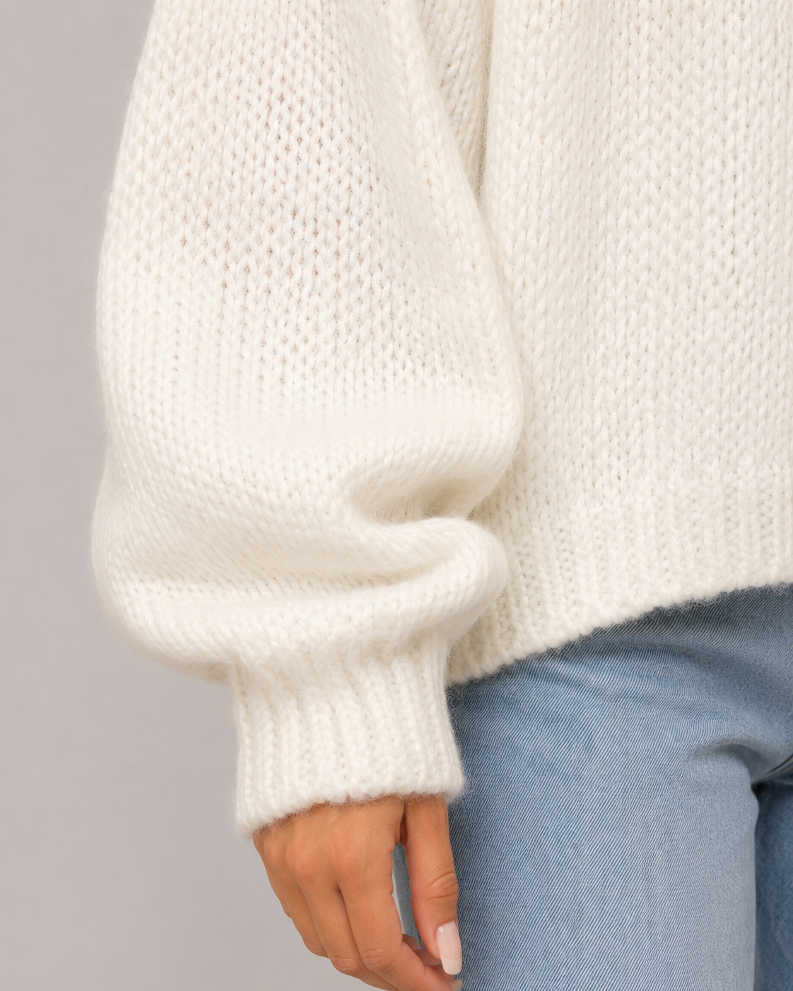 Jersey blanco de punto grueso, detalle de manga amplia y puño acanalado