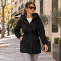 Parka negra con capucha y cintura ajustable, cierre frontal con botones y bolsillos