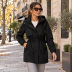 Parka negra con capucha y cintura ajustable, cierre frontal con botones y bolsillos