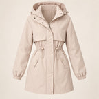 Parka beige con capucha, pechera con botones y puños elásticos, diseño entallado.