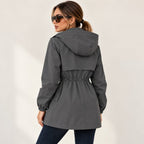 Parka gris grafito con capucha y espalda entallada, cintura fruncida y cordones.