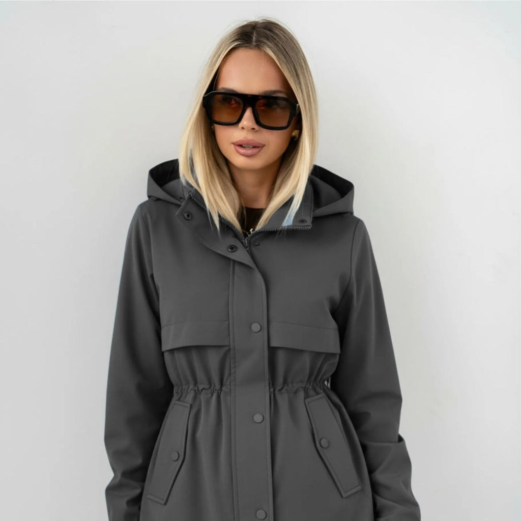 Parka gris grafito con capucha, cierre frontal y bolsillos con solapa, puños elásticos.