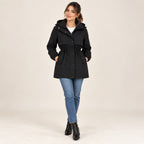 Parka negra con capucha, cintura entallada con cordón y bolsillos frontales con botones