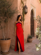Vestido largo rojo con tirantes halter, diseño cruzado y abertura lateral en pierna.