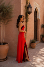 Vestido largo rojo halter con diseño cruzado y abertura lateral, vista lateral.