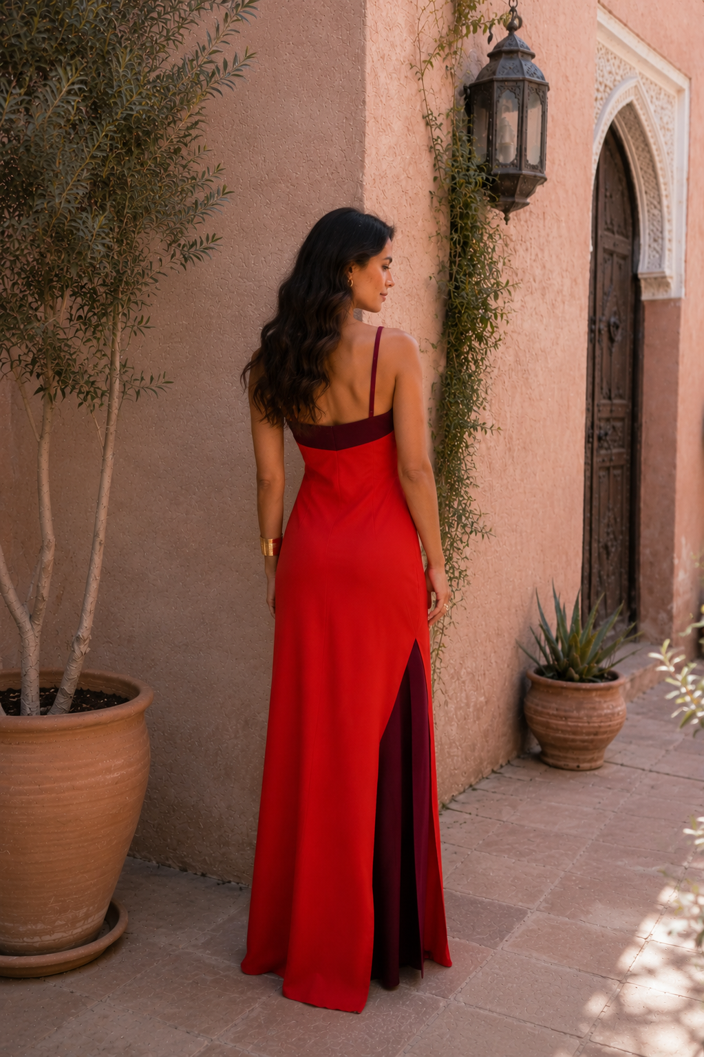 Vestido largo rojo con tirantes halter cruzados y abertura lateral, espalda descubierta.