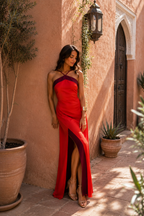 Vestido largo rojo con tirantes halter y abertura lateral, diseño cruzado y caída ajustada.