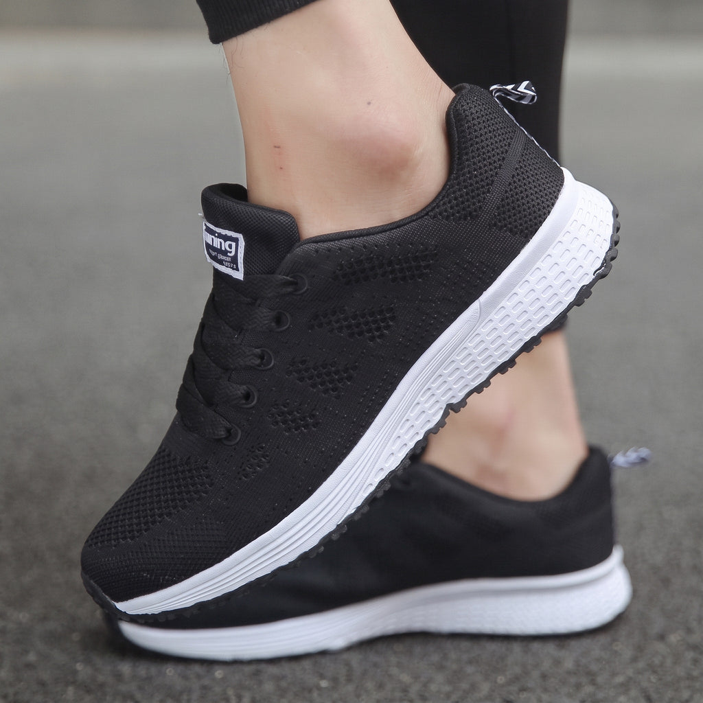 Zapatillas transpirables negras con cordones, talón acolchado y suela blanca
