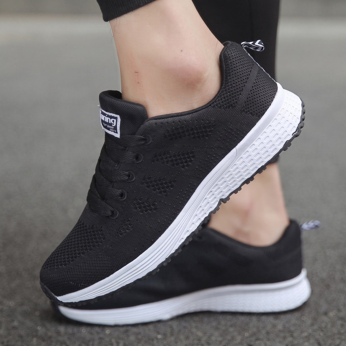 Zapatillas transpirables negras con cordones, talón acolchado y suela blanca
