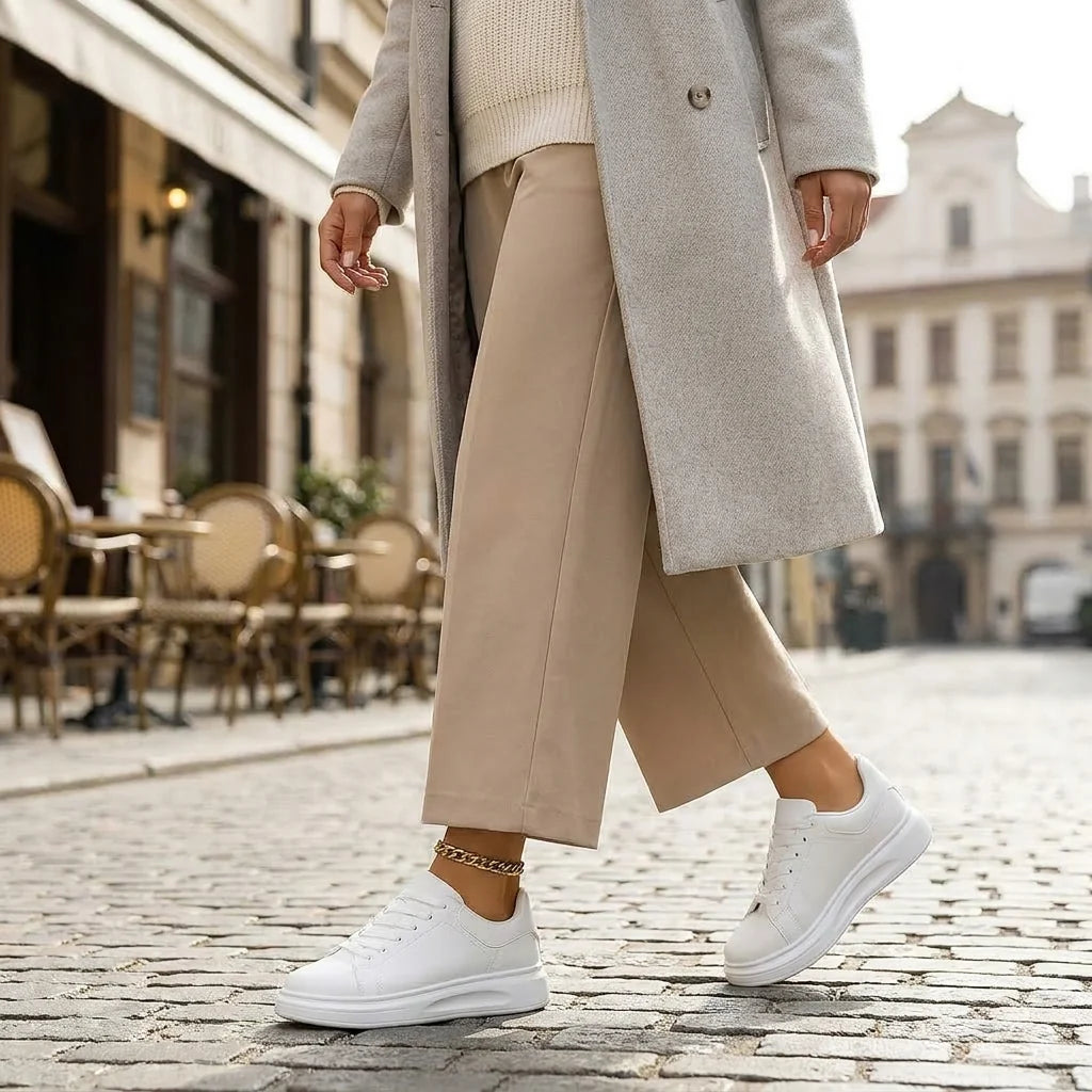 Zapatillas blancas de caña baja con cordones y suela gruesa, con pantalón beige