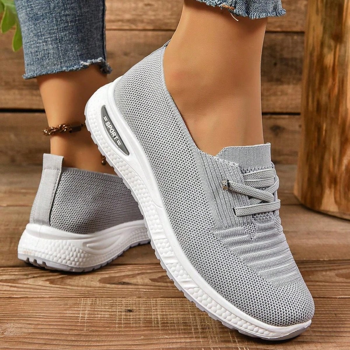 Zapatillas grises sin cordones con tejido de malla transpirable y suela blanca gruesa