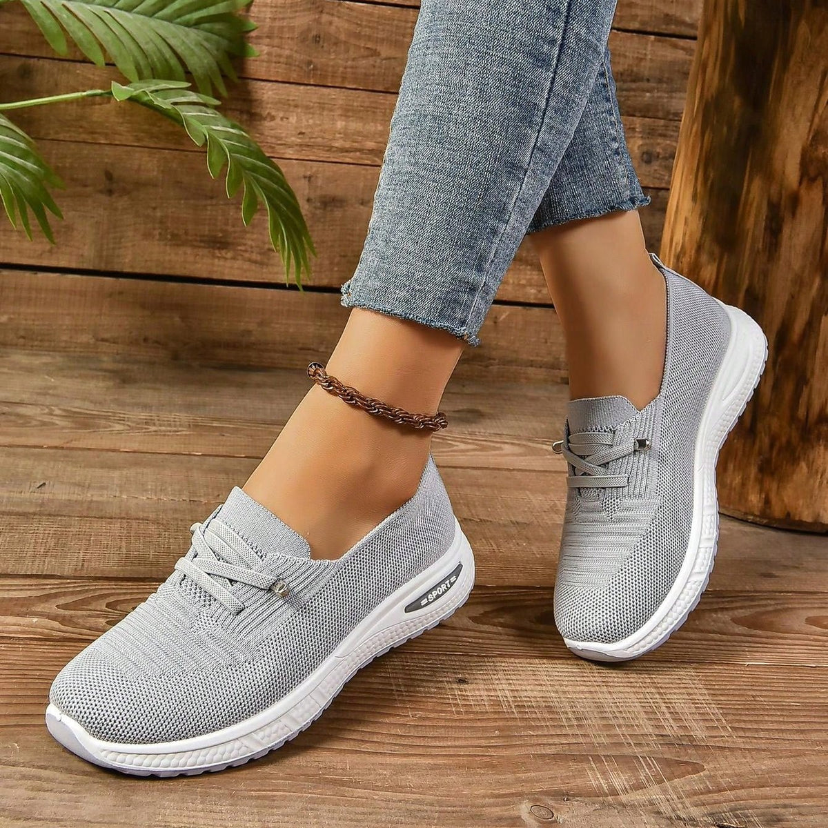 Zapatillas grises sin cordones, empeine de malla transpirable y suela blanca perfilada