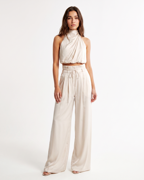 Witte dames jumpsuit met halterhals en wijde pijpen, strikceintuur en knoopsluiting