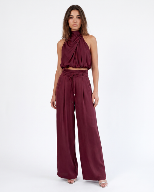 Bordeauxrode dames jumpsuit met halterhals, wijde pijpen en strikceintuur