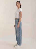Wijde jeans voor dames in lichtblauw denim, zijaanzicht met brede pijpen en zakken.