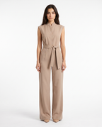Beige mouwloze jumpsuit met strikceintuur en wijde broekspijpen, rits vooraan
